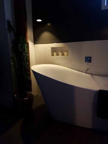 Focal night time view of the bath with only the pendant light above the bath on sets an amazing relaxing feel at Dudley Ave